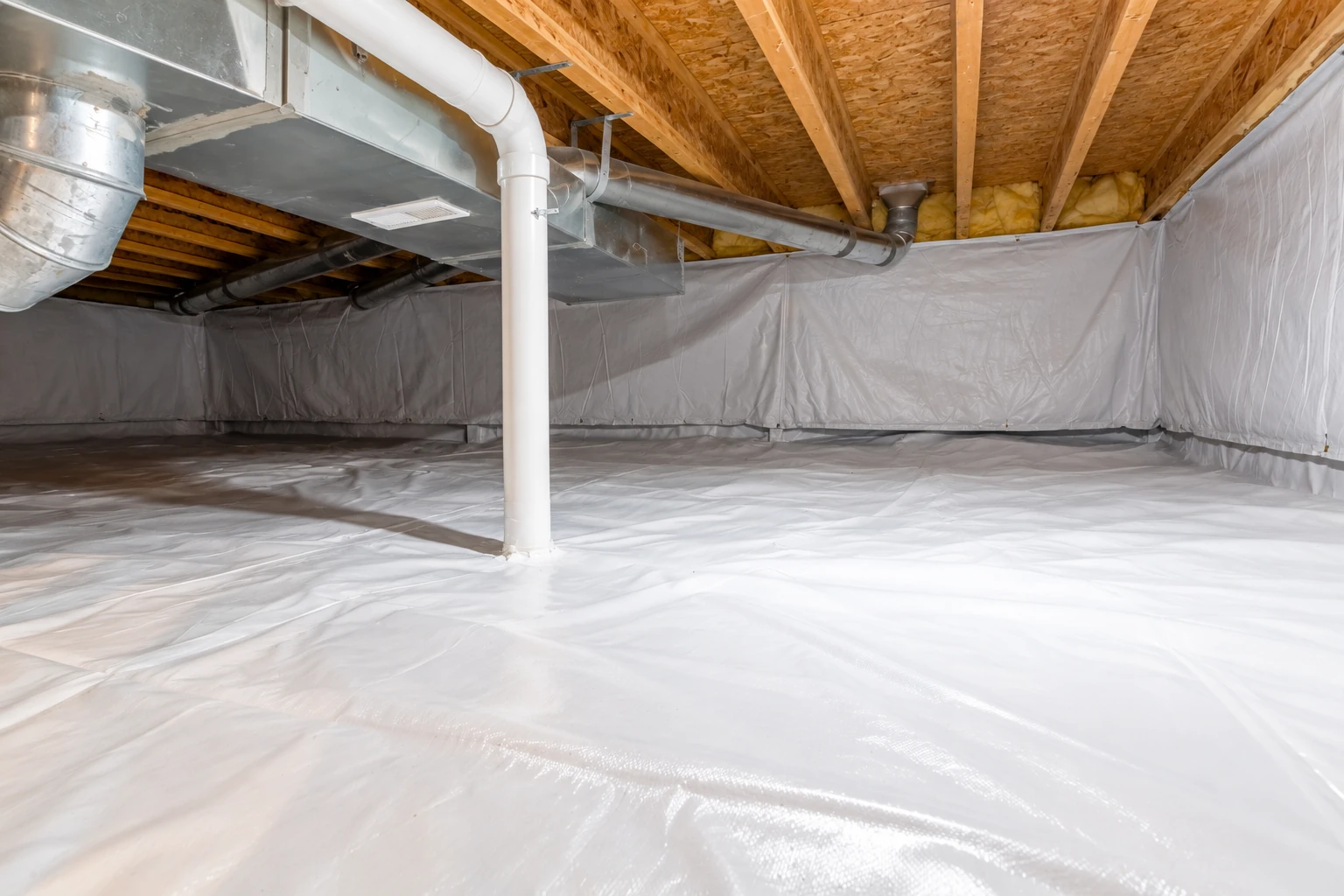 Crawl space with a white plastic vapor barrier covering the floor and walls beneath exposed joists and ductwork.